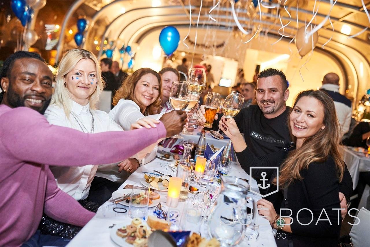 A group of people celebrating New Year's Eve on a boat decorated with balloons