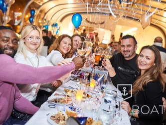 en:A group of people celebrating New Year's Eve on a boat decorated with balloons; fr:Groupe de personnes qui fête le nouvel an sur un bateau décoré de ballons