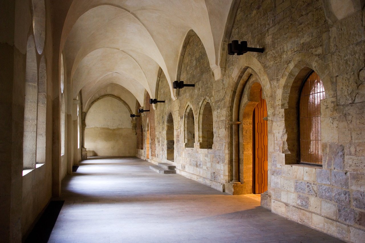 vaulted stone corridor with arched windows on the side